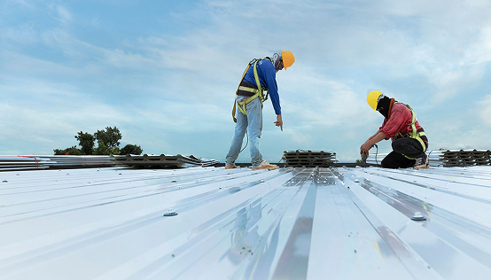 stock-photo-construction-worker-in-work-clothes-installing-new-roofing-tools-roofing-tools-electric-drill-and-2189130963