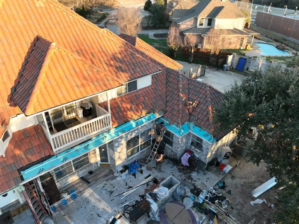 Exposed roof sheathing and underlayment during tile roof edge repair in Texas