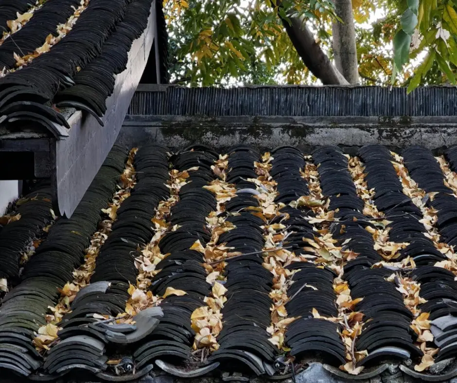 Clogged roof valley with leaves and twigs on a Dallas clay tile roof.